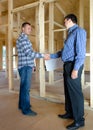 Two men shaking hands in a new build house Royalty Free Stock Photo