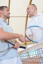 Two men shaking hands over tennis court net Royalty Free Stock Photo