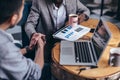 Two men shaking hands while sitting at the desk. Royalty Free Stock Photo