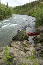 Two men beaching canoes beside Alaskan river rapid Royalty Free Stock Photo