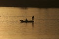 Fishing from a small boat on a river at sunset Royalty Free Stock Photo