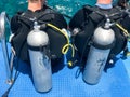 Two men are sitting in black diving suits with tubes and metal oxygen tanks ready for immersion Royalty Free Stock Photo