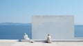 two men sitting on the edge of a building near a white wall