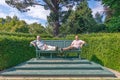 Two men sitting on a giant bench, Bodnant garden, Wales