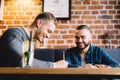 Two men sitting in a restaurant and laughing. Royalty Free Stock Photo