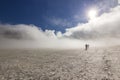 Two men on snowy field in kamchatka mountains with clouds and sky above Royalty Free Stock Photo