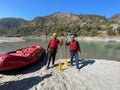 two men standing in front of their raft near the river