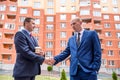 Two men in suits with clipboard and keys negotiate