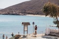 Two men taking photos of Panormos Beach sign, Mykonos, Greece