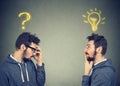 Two men thinking one has a question another solution with light bulb above head Royalty Free Stock Photo