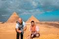 Two men travelers posing in front of the great pyramids of giza in cairo egypt. Traveling egypt during the winter, cold winter Royalty Free Stock Photo