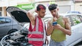 Two men using smartphone with insurance for car breakdown at street Royalty Free Stock Photo