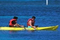 Two men on vacation sailing a yellow canoe