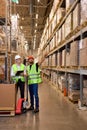 two men warehouse workers with hand pallet jack lift stand having talk, temwork