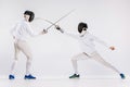 The two men wearing fencing suit practicing with sword against gray Royalty Free Stock Photo