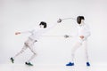 The two men wearing fencing suit practicing with sword against gray Royalty Free Stock Photo