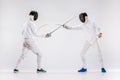 The two men wearing fencing suit practicing with sword against gray Royalty Free Stock Photo