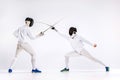 The two men wearing fencing suit practicing with sword against gray Royalty Free Stock Photo