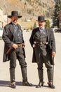 Two men wearing moustaches and vintage Old West Sheriff outfits