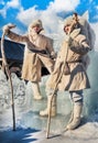 Two men in white fur coats standing next to the ice throne. Farewell to winter in