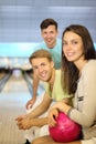 Two men and woman with ball sit in bowling club Royalty Free Stock Photo