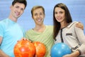 Two men and woman hold balls in bowling club Royalty Free Stock Photo