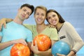 Two men and woman hold balls in bowling club Royalty Free Stock Photo