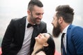 Two men and a woman in love triangle, smiling resumed in the foreground Royalty Free Stock Photo