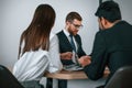 Two men and woman are sitting in the office and working Royalty Free Stock Photo