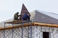 Two men are working on a roof, one of them is wearing a yellow jacket Royalty Free Stock Photo