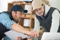 two men in workshop looking at computer screen Royalty Free Stock Photo