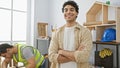 Two men in a workshop, one smiling confidently at the camera, the other working intently in the background Royalty Free Stock Photo