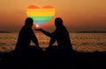 Two mens representing a homosexual couple , holding a heart with lgbt symbols Royalty Free Stock Photo