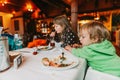 Two messy kids eating lunch in restaurant