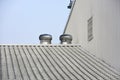 Two of metal air ventilators or air blower cooling on the metal sheet factory roof spinning take cool wind into the building