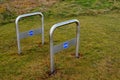 Two metal chrome bicycle stands on a grass