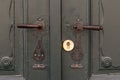 Two metal old door handles on green wooden doors. Royalty Free Stock Photo