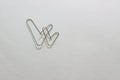 Two metal paper clips in the form of two checkmarks on a white paper sheet. Two hearts made of paper clips on a white background. Royalty Free Stock Photo