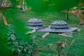 Two metal podpeka or sache lids with charcoal on top at a garden party. View of typical metal sache pots looking through leaves on Royalty Free Stock Photo