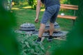 Two metal podpeka or sache lids with charcoal on top at a garden party. View of typical metal sache pots looking through leaves on Royalty Free Stock Photo