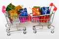 Two metal shopping carts filled with colorful gifts are pitted against each other. Advertising and sale. Holiday shopping in the