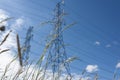 Two metal transmission towers and a blue cloudy sky