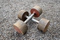 Two metallic dumbbells on ground outdoors