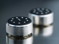 Two metallic rotary control knobs with black tops featuring white markings on a reflective surface showcasing modern industrial Royalty Free Stock Photo