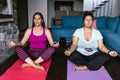 Two mexican women with closed eyes meditating in lotus position at home in Mexico