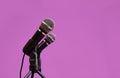 Two microphones isolated on deep mauve background, communication concept