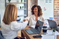 Two middle age beautiful businesswomen smiling happy and confident working together Royalty Free Stock Photo
