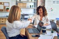 Two middle age beautiful businesswomen smiling happy and confident working together Royalty Free Stock Photo