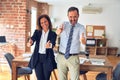 Two middle age business workers standing working together in a meeting at the office approving doing positive gesture with hand, Royalty Free Stock Photo