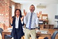 Two middle age business workers standing working together in a meeting at the office celebrating mad and crazy for success with Royalty Free Stock Photo